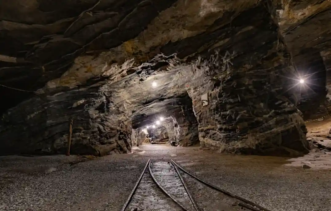 Underground mine tunnel with rail tracks and lighting